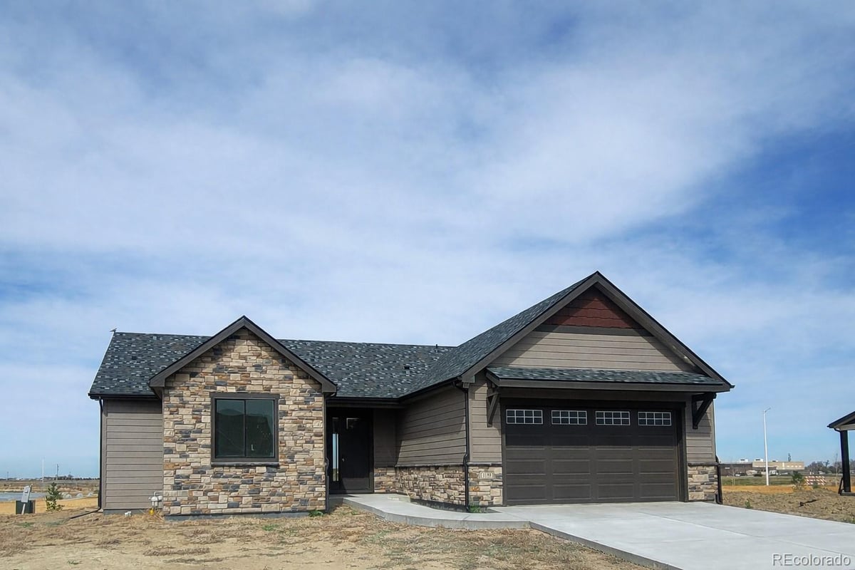 Front exterior of a two-story home with siding and brick accents