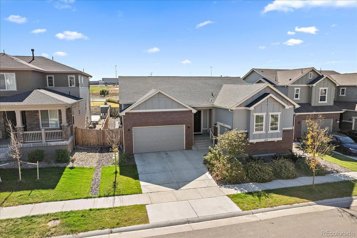 Front exterior of a two-story home with siding and brick accents