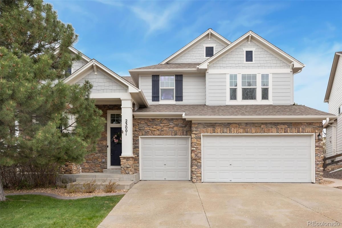 Front exterior of a two-story home with siding and brick accents