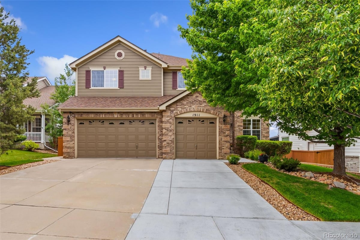 Front exterior of a two-story home with siding and brick accents