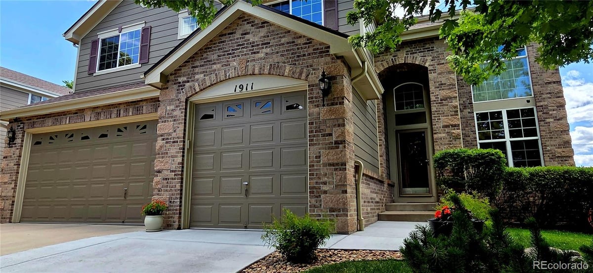 Front exterior of a two-story home with siding and brick accents